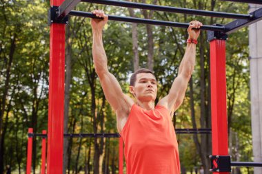 Sporcu adam yazın parkta spor yapıyor. Çocuk parkında.