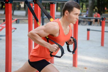 Sporcu adam yazın parkta spor yapıyor. Çocuk parkında.