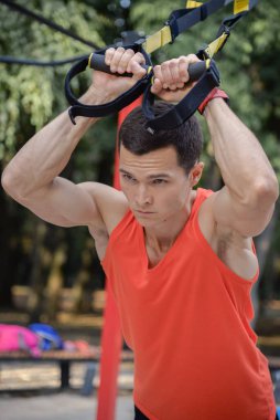 Sporcu adam yazın parkta spor yapıyor. Çocuk parkında.