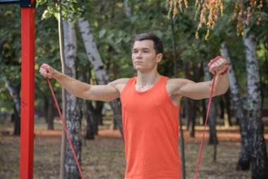 Sporcu adam yazın parkta spor yapıyor. Çocuk parkında.