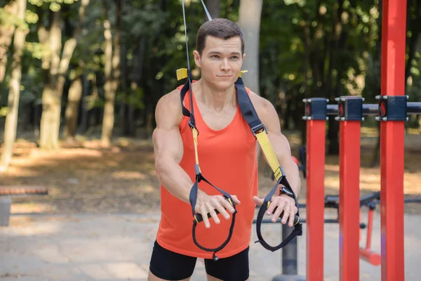 Sporcu adam yazın parkta spor yapıyor. Çocuk parkında.