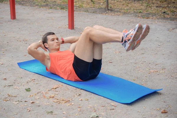 Sporcu adam yazın parkta spor yapıyor. Çocuk parkında.