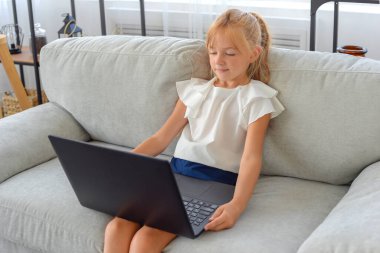 Okuldaki ilk günüm. Sevimli ve mutlu küçük kız çocukları dizüstü bilgisayar kullanıyor, online e-öğrenim sistemi üzerinden çalışıyorlar.