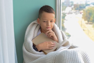 Okula dönelim. Gözlüklü komik çocuk okuyor. İlkokuldan bir çocuk ve okulda bir kitabı var. Eğitim.