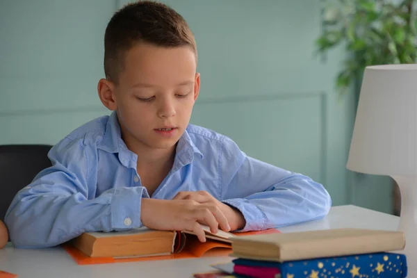 We return to school. Happy smiling pupil draws at the table. Child in class room