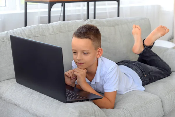 Dizüstü bilgisayarı olan okul çocuğu ev ödevi yapıyor. çevrimiçi öğrenme