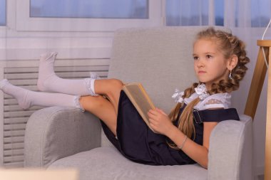 Kız öğrenci evde bir kitap okudu. evde eğitim kavramı