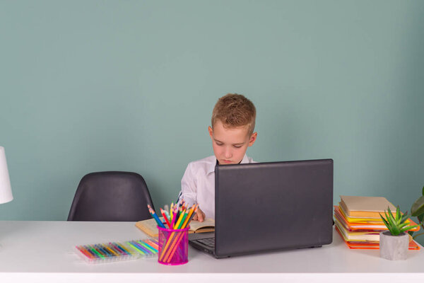 Back to school! A cute hardworking child is sitting at a laptop at school. boy studying in class