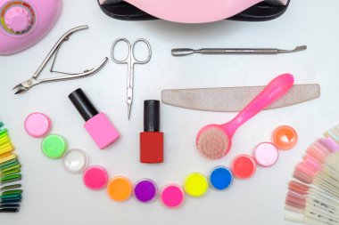 Tırnak bakımı. Güzel kadın elleri pembe ojeli oje ile oje yapar. Profesyonel manikür aletlerinin yanında bir kadın eli. Güzellik bakımı