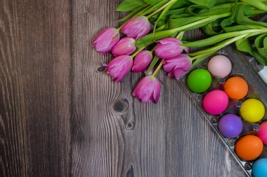 Ahşap bir zemin üzerinde paskalya yumurtaları ve laleler. Yüksek kalite fotoğraf