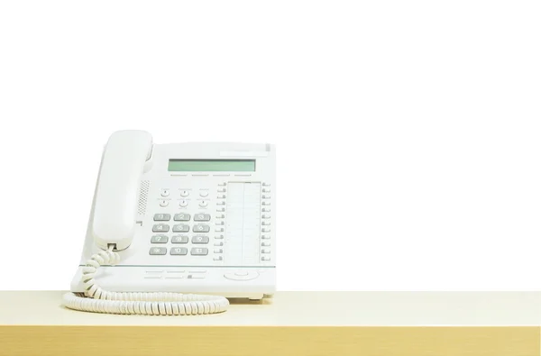 Nahaufnahme weißes Telefon, Bürotelefon auf verschwommenem Holzschreibtisch im Besprechungsraum unter Fensterlicht isoliert auf weißem Hintergrund — Stockfoto