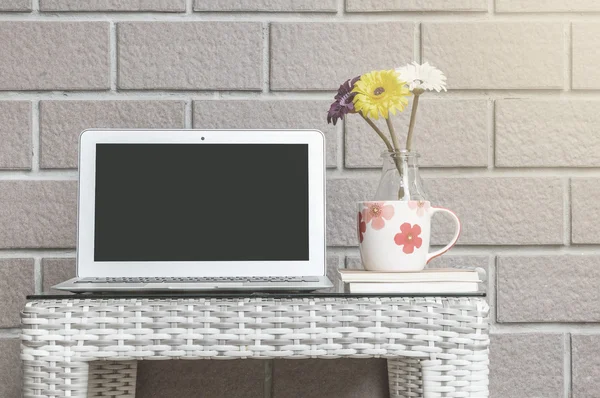 Computadora de primer plano sobre tabla de tejido de madera borrosa y fondo de textura de pared de ladrillo marrón, hermoso lugar de trabajo interior del concepto de casa — Foto de Stock