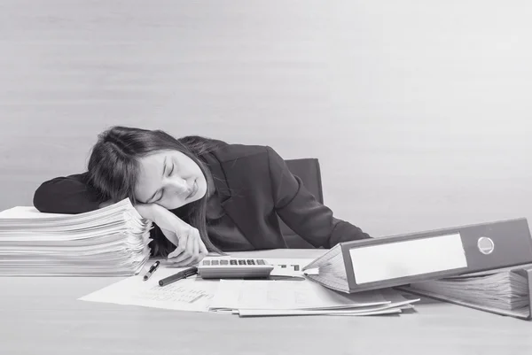 Closeup working woman sleeping after she tired from work with work paper and document file on desk and wall textured background in meeting room , tired working woman concept in black and white tone