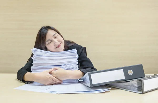 Primo piano felice donna che dorme dopo aver finito il suo lavoro con carta da lavoro e file di documenti su una scrivania in legno sfocato e sfondo strutturato a parete nella sala riunioni, donna ama il suo concetto di lavoro — Foto Stock