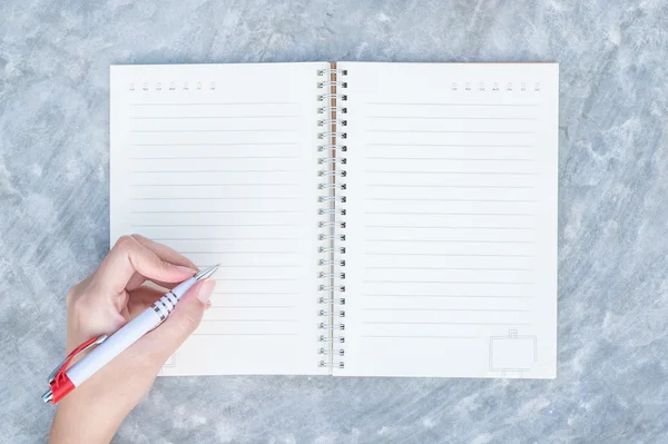 Nahaufnahme Frau Handschrift auf Notizbuch auf Betonschreibtisch in Draufsicht strukturierten Hintergrund unter Tageslicht im Garten — Stockfoto