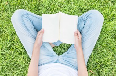 Sabah, okumak için genel bahçede çim sahada oturan kadın dinlenmek zaman Asyalı kadın