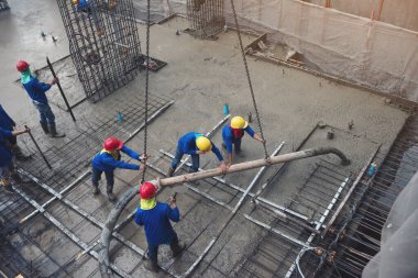 Mavi kasklı ve inşaat alanı projesiyle uğraşan işçi. İnşaatçı ustabaşı işgali betonla zemin iş kulesi yapmaya çalışıyor. Endüstri mimari geliştirme kavramı. 