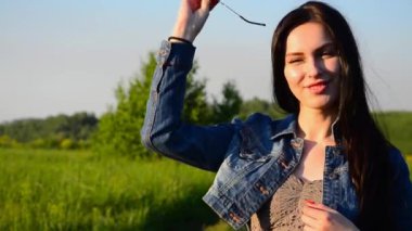 esmer açık havada gözlük takıyor. esmer güneş gözlüğü açık havada ve gülümseyen giyer. gülümseyen ve batımını gözlüklü kız