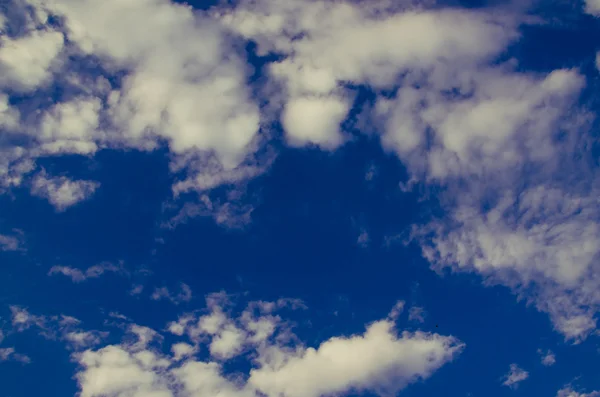 Nuvens cumulus flutuar através do céu azul — Fotografia de Stock