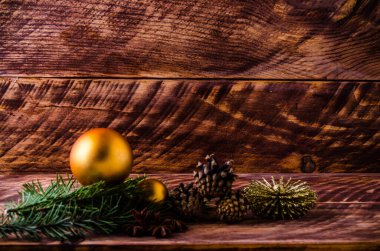 Büyük bir Noel balosuyla tahta tahtaların üzerinde koniler ve dallar