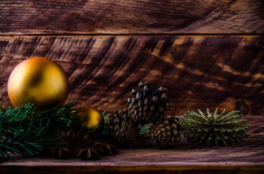 Büyük bir Noel balosuyla tahta tahtaların üzerinde koniler ve dallar