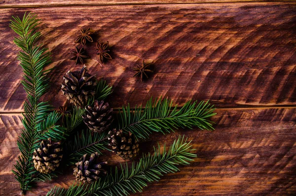 木製ボード上のクリスマスコーンと枝 — ストック写真