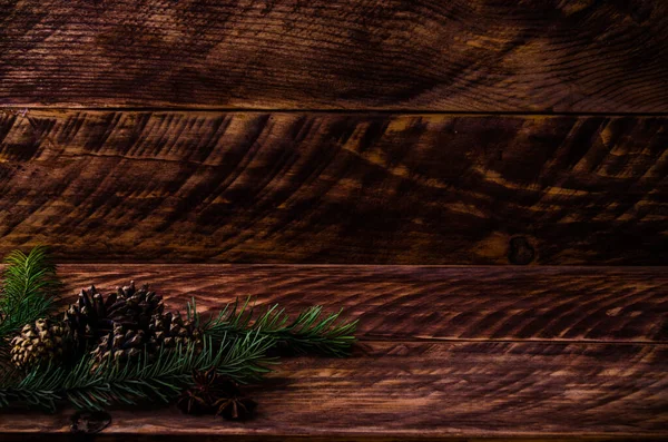 木製ボード上のクリスマスコーンと枝 — ストック写真