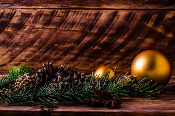 Büyük bir Noel balosuyla tahta tahtaların üzerinde koniler ve dallar