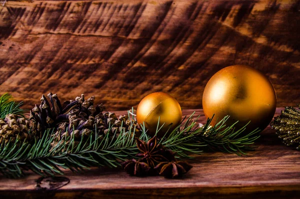 Büyük bir Noel balosuyla tahta tahtaların üzerinde koniler ve dallar