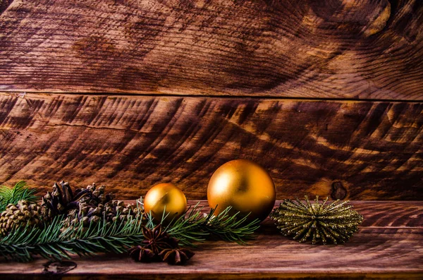 Büyük bir Noel balosuyla tahta tahtaların üzerinde koniler ve dallar