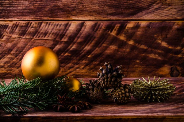 Büyük bir Noel balosuyla tahta tahtaların üzerinde koniler ve dallar