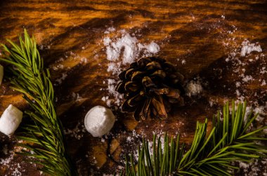 Noel konileri ve dalları tahta marshmallow tahtalarında.