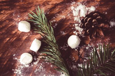 Noel konileri ve dalları tahta marshmallow tahtalarında.