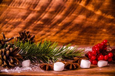 Kırmızı viburnum. Noel konileri ve dalları marşmelovlu tahta tahtalarda.