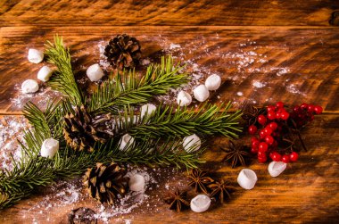 Kırmızı viburnum. Noel konileri ve dalları marşmelovlu tahta tahtalarda.