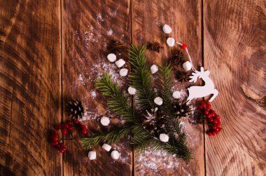 Kırmızı viburnum. Noel konileri ve ağaçların üzerinde marşmelovlu dallar. Kar taneleri ve geyik heykelleri