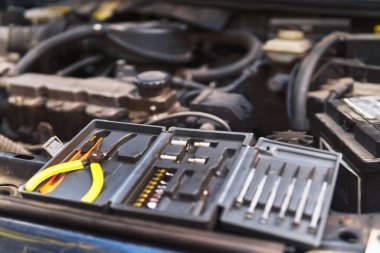 Alet çantalı çanta kaputun üzerinde. İngiliz anahtarı, ayarlanabilir anahtar, ucu, pense, tornavida, makine onarımı..