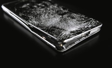 Koyu arkaplanda kırık ekranlı akıllı telefon