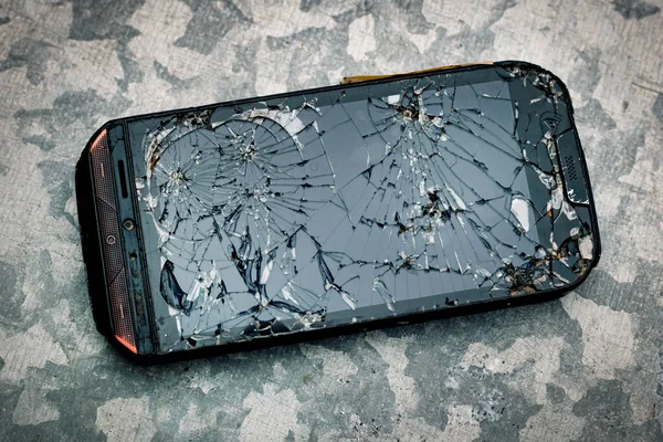 Modern smartphone with a damaged glass screen on a black background. The device needs repair.