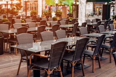 Sokakta boş kafe, boş masalar ve sandalyeler.