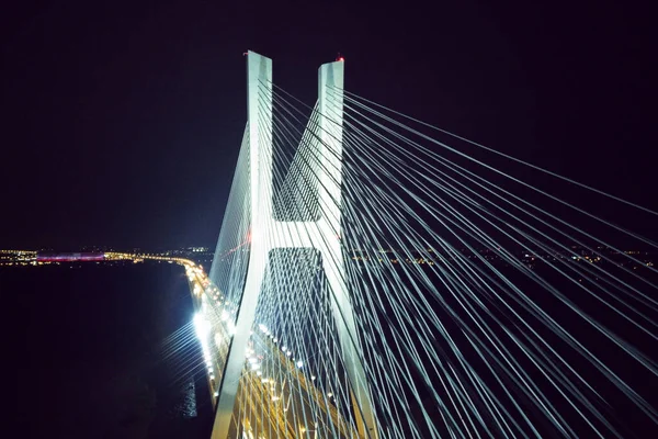 Geceleri köprünün mimarisi olan kuş bakışı bir köprüden ışıl ışıl parlıyor. Kablolar, Wroclaw