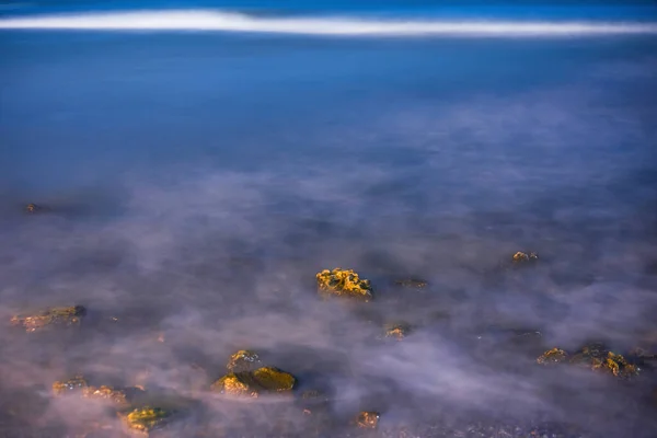 海水は 長時間露光で石を洗います 夜の海 — ストック写真