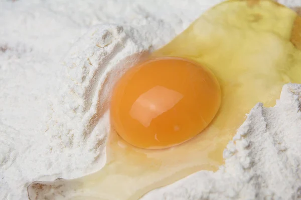 Fresh raw chicken eggs in flour close-up. Mix broken raw eggs and wheat flour, homemade cookies