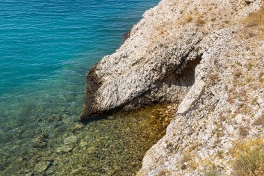 Kristal berrak suyun havadan görünüşü güneş ışığını ve tepeleri yansıtıyor. Deniz yazı manzarası. Hırvatistan 'ın Pag adası plajı.