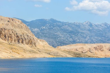 Açık güneşli bir günde mavi deniz ve kumlu dağ sırtı. Tatilde deniz manzarası, denizde ıssız adalar