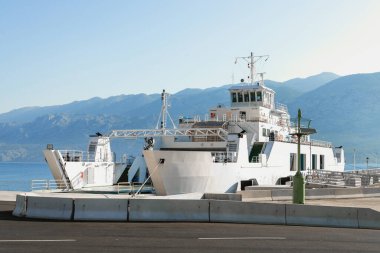 Güneşli bir yaz gününde limanda bekleyen feribot görüntüsü limana demirlemiş büyük bir gemi, bir araba feribotu. Hırvatistan