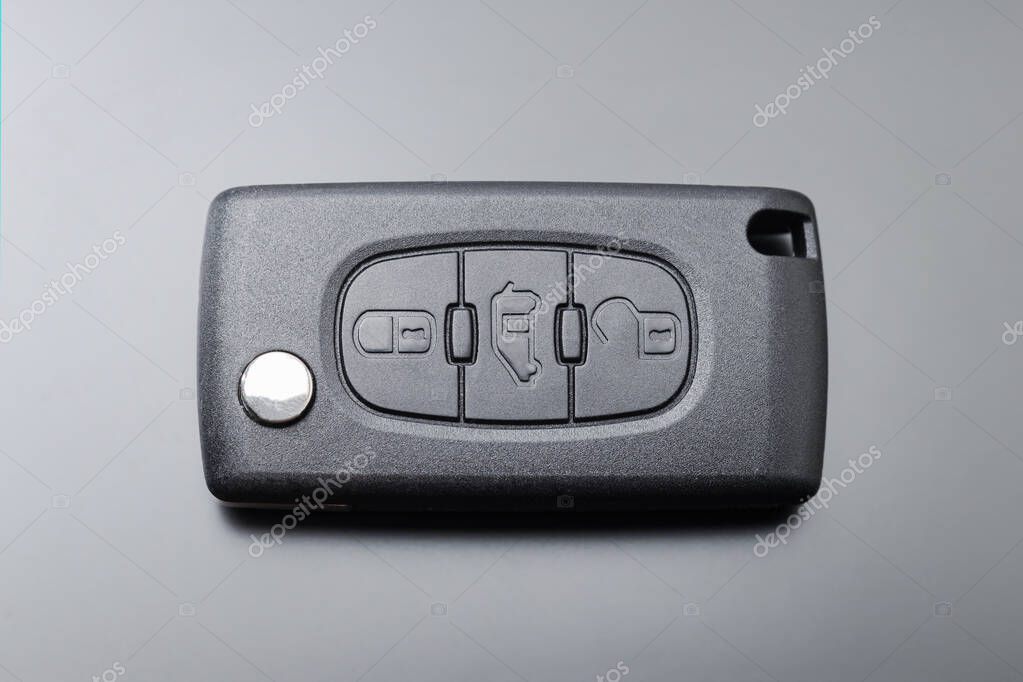Modern car key with remote control, on black background