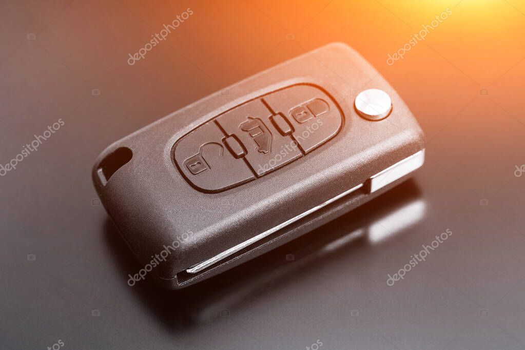 Modern car key with remote control, on black background