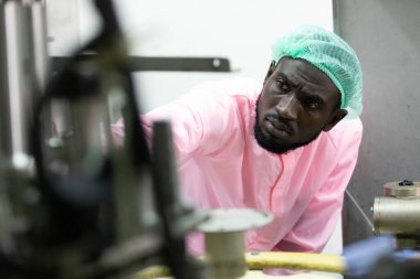 Afrikalı erkek fabrika işçisi fabrikada eski bir makine gibi görünüyor 