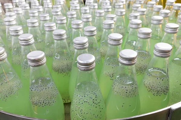 close up kiwi green fruit juice drink in a bottle, production line